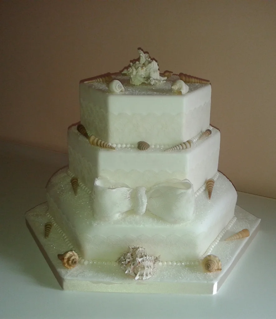 White three tiered cake with shells
